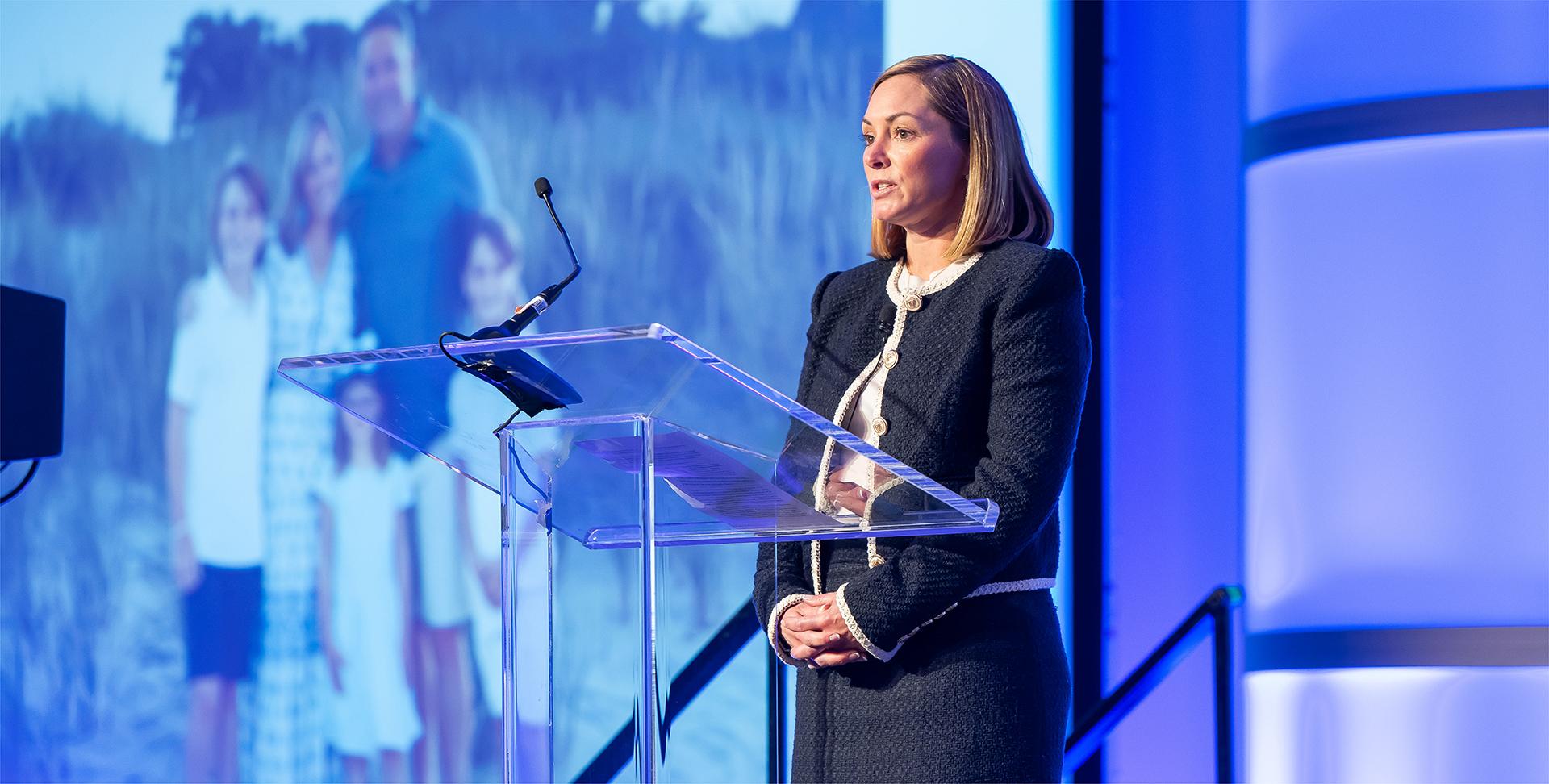 Woman behind a podium giving a presentation
