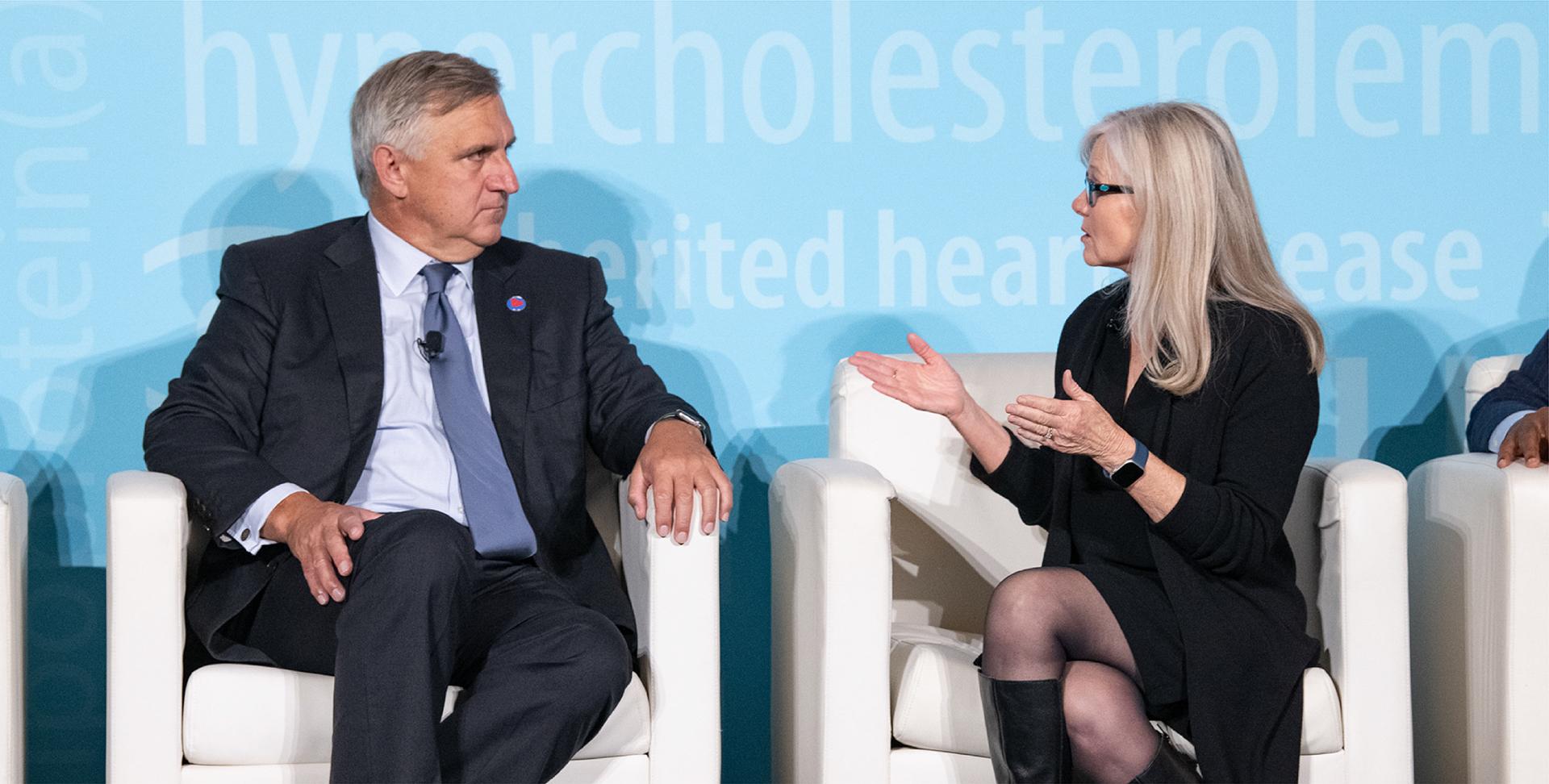A man and a woman sitting on stage having a conversation